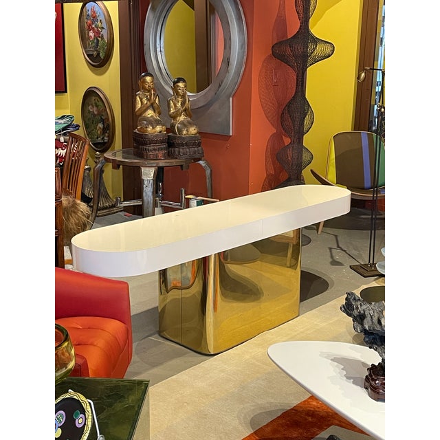 This is a really versatile console in gorgeous brass with an acrylic top. The height makes it ideal to place behind a sofa.