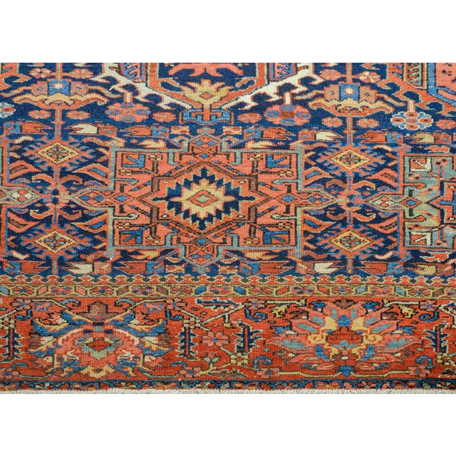 An incredible early 20th century Persian Karaje Serapi rug with a field of all-over large-scale stylized flowers amidst a...