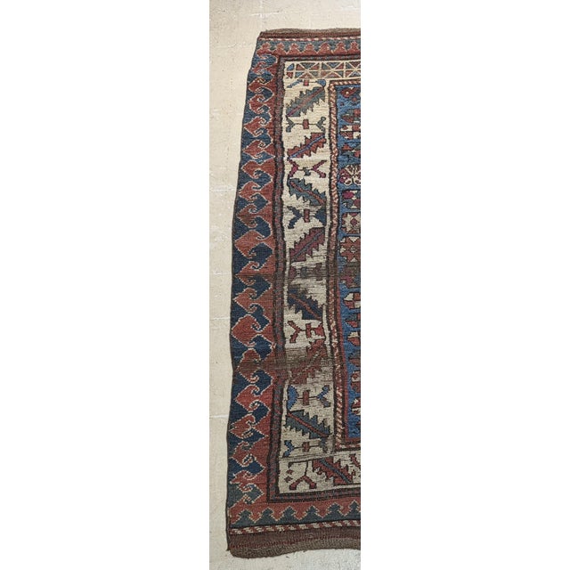 Antique hand-knotted Caucasian Kazak rug featuring a striking geometric composition of stacked medallions surrounded by...