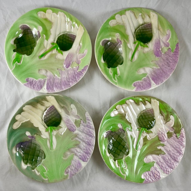 A Saint Clément French Faïence, a majolica glazed plate showing overlapping asparagus spears, leaves and globe artichoke...