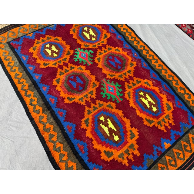 This vibrant 3'2" x 4'6" vintage Afghan handwoven kilim rug captures the essence of traditional tribal artistry through...