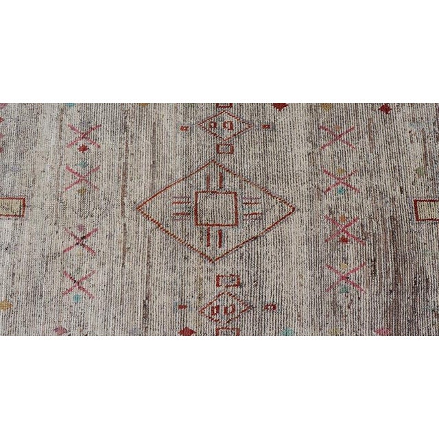 Measures: 2'9 x 9'7. This modern casual tribal rug has been hand-knotted. The rug features a modern sub-geometric diamond...