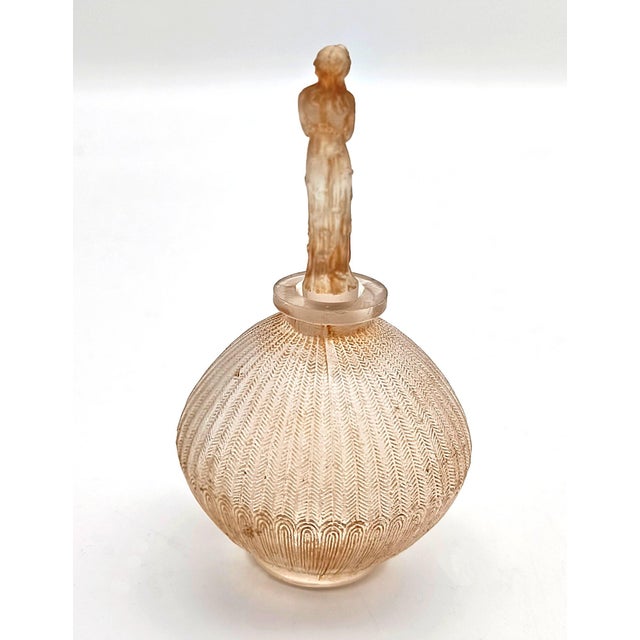 A stunning and highly collectible early glass perfume bottle designed by René Lalique in 1914 for the prestigious French...