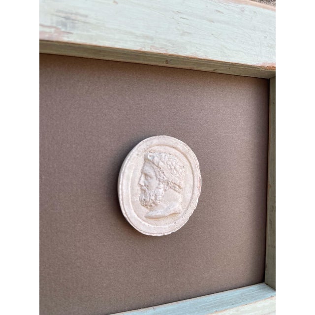 Immerse yourself in the enduring allure of classical antiquity with this truly unique collection of framed intaglios....