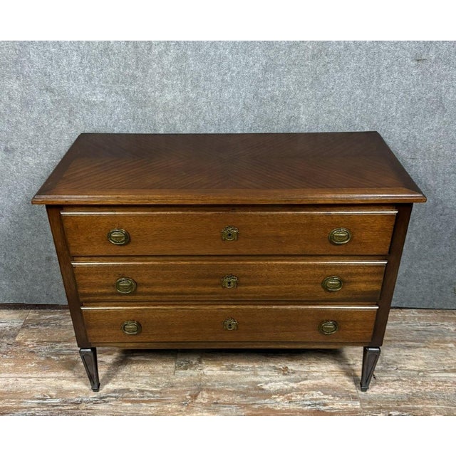 Louis XVI style mahogany chest of drawers, 20th century. Three drawers. Wooden top. Patinated brass drawer pulls and...