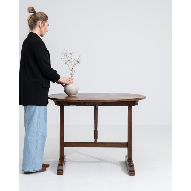 A 19th century French wine tasting table crafted in oak, designed with a folding mechanism for practical use. The circular...
