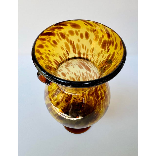 Large hand-blown art glass vase with a luminous amber and dark brown tortoiseshell pattern. The tall amphora form has a...
