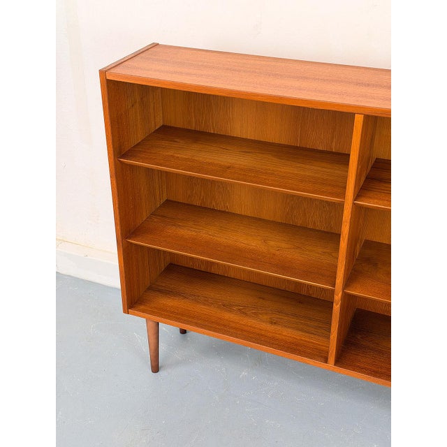 High-quality and timeless teak bookcase with four adjustable shelves, each with a beveled front. The shelves slide onto...