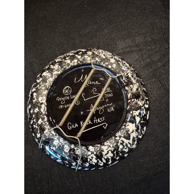 This round, hand-painted ceramic piece is an authentic Mana Pottery wall plate. It showcases a galloping black horse...