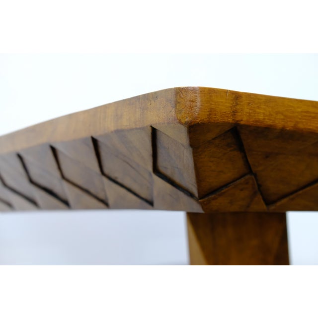 A sculptural solid wood game table by Brazilian architect and designer José Zanine Caldas. The rectangular top features a...