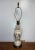 Vintage mid-century porcelain table lamp with colorful floral decoration, white body, and brass-tone base. Classic...