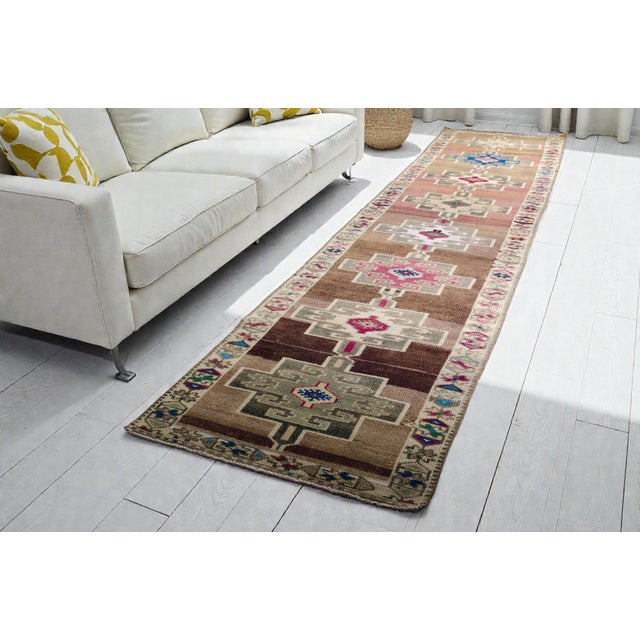 This is a vintage Turkish Oushak rug from the Mid 20th Century. The piece was hand-knotted.