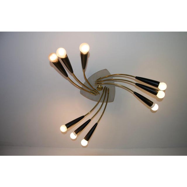 Mid-century brass sputnik chandelier, germany, 1950s. This striking vintage ceiling light features a dynamic sculptural...