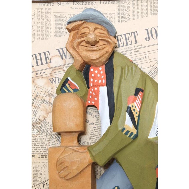 A painted wood carving of a character by listed 20th century artist Duff Tweed. This piece presents a wood carving of a...