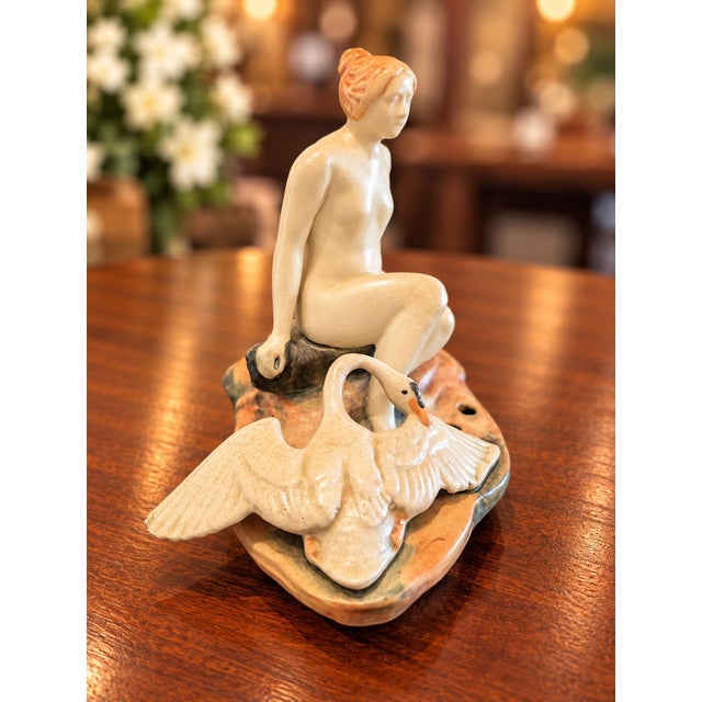 Beautiful antique Weller Muskota “Leda and the Swan” figural flower frog, featuring a graceful seated nude woman...