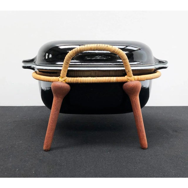 This black casserole dish and stand was designed in 1954 by jens quistgaard, a danish sculptor and industrial designer,...