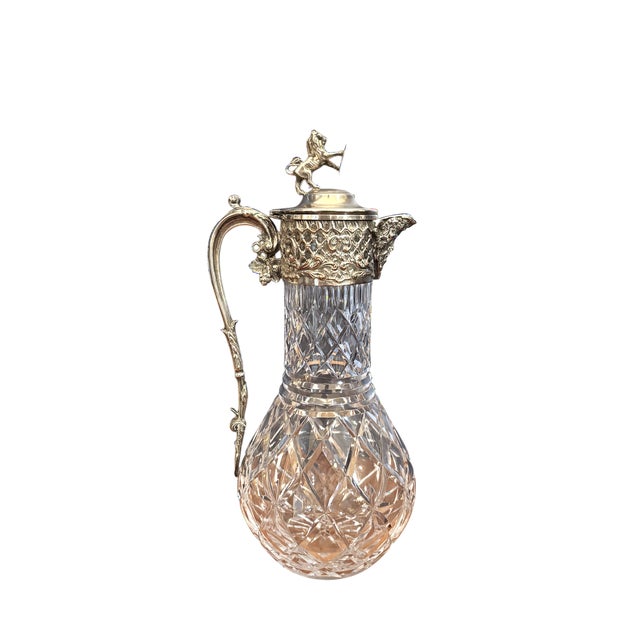 Exceptional cut-crystal diamond pattered pitcher/claret jug with intricate repoussé silverplate collar and sweeping...