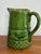 A rustic and antique earthenware pitcher in a striking green glaze. Please see condition details noted. Most items found...