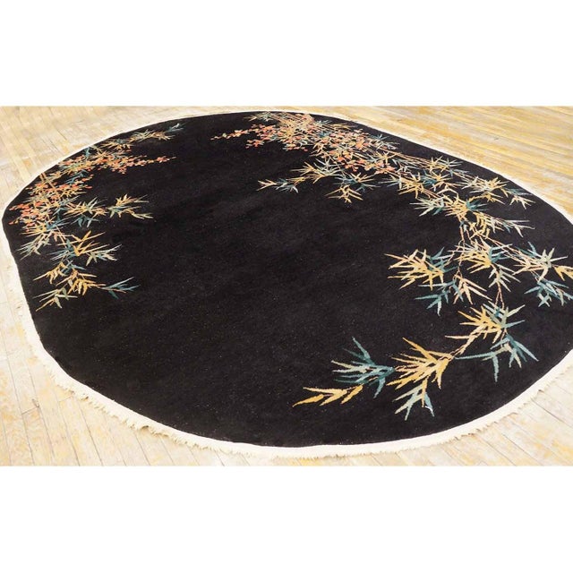 Antique Art Deco Chinese Floral Black 1920s Oval Rug, Circa Date: 1920s. This exceptional Chinese Art Deco piece from the...