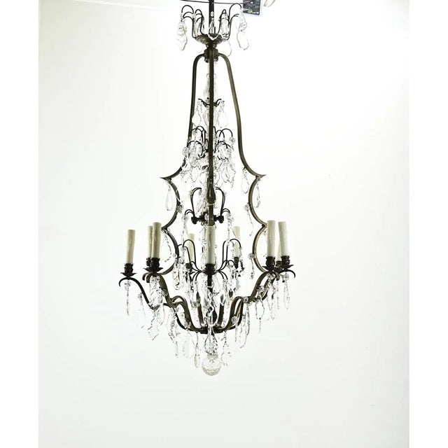 A dazzling French 9-light cast brass and crystal chandelier from the 1800s. This large, whimsical fixture has an...