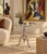 A distinctive aluminum accent table with a polished oval top, turned pedestal, and three curved feet. The top and pedestal...