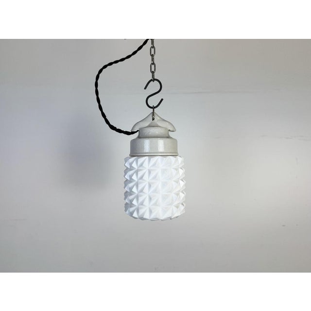 Vintage industrial light made in former Czechoslovakia during the 1970s. It features a white porcelain top and a glass...