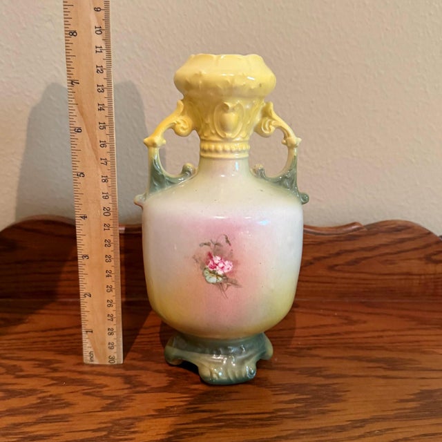 This lovely Austrian amphora vase showcases a classic shape with elegant handles and a beautiful, hand-applied rose decal....