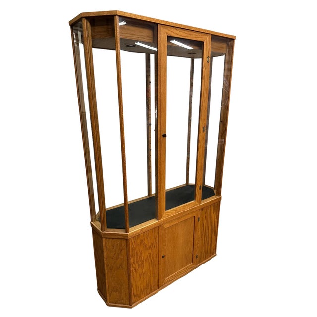 Beautiful vintage oak and glass display cabinet, circa 1980s. It is lighted internally, with a locking rear glass door....