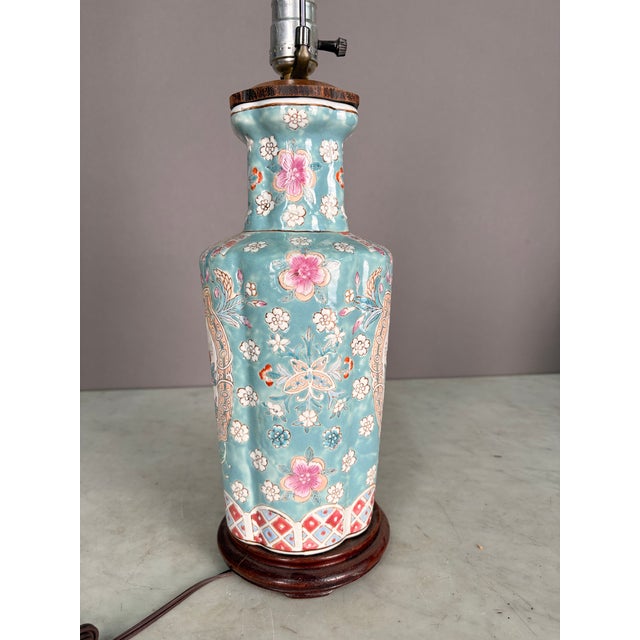 Traditional Chinese Famille Rose table lamp in baby blue with white and pink accents. Porcelain vase and dark teak wood...