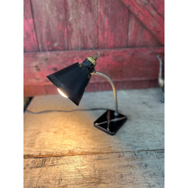 This antique 1930s Art Deco desk lamp by Chase Brass & Copper Co. features a black metal shade, adjustable neck, and...