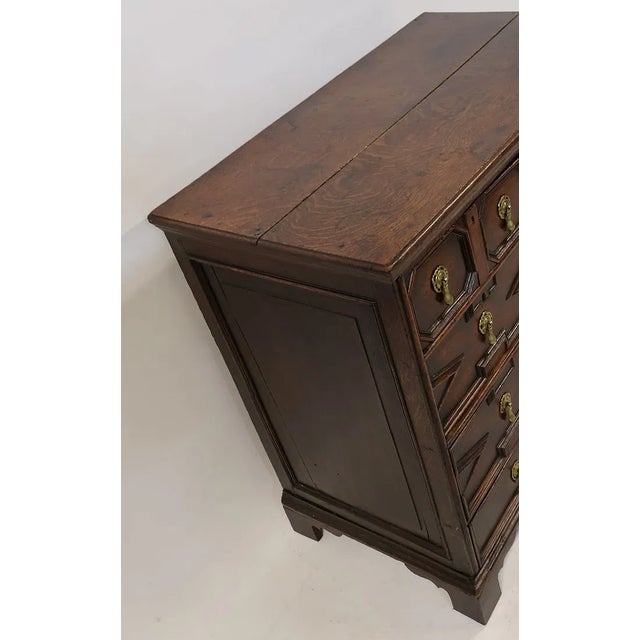 A handsome early 18th century English oak chest of drawers featuring a richly molded geometric facade and exceptional...