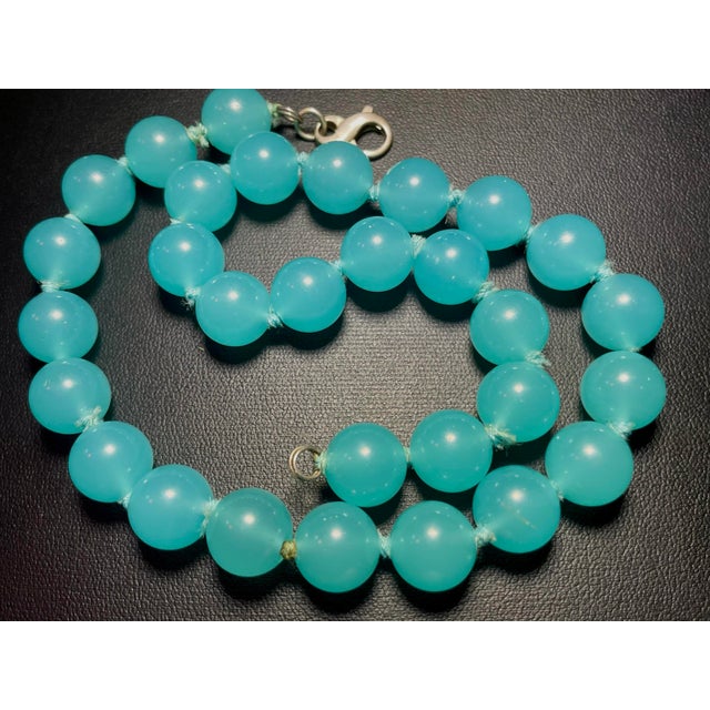 The Peking glass has a soft, milky translucency, in aqua-blue hue, with a subtle inner glow. Necklace is strung with...