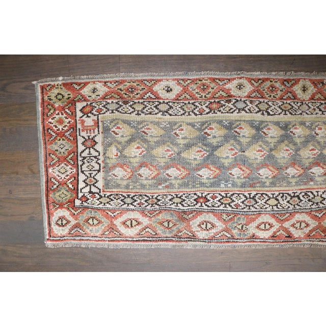 an early 20th century Persian Kurd Mini size rug featuring a boteh design