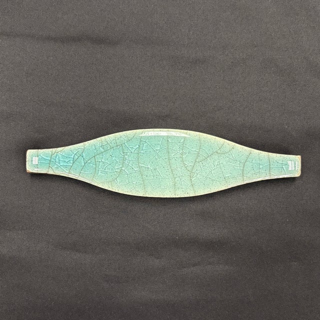 1-5/8" x 6-1/4" ceramic field tile with a turquoise glaze and a glossy crackled finish. Tiles are handmade and hand...