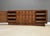 A mid century modern walnut long Tobago brutalist dresser with two doors and sculpted pulls. Made in Canada....