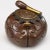 A small inkwell with a globular body and a lid shaped like a Buddhist mokugyo drum and beater. The heavy copper body has...