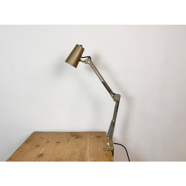 Vintage brown adjustable table lamp made in former Czechoslovakia during the 1960s. It features a metal lampshade with...