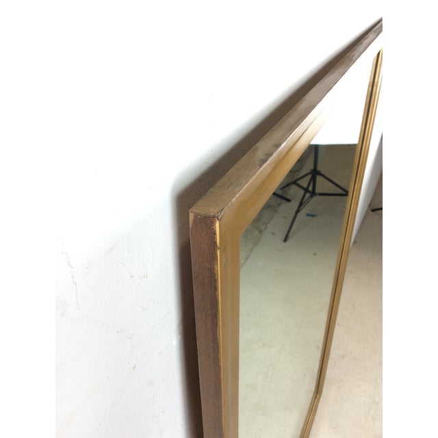 This mid century modern mirror features hardwood frame, original blonde wood finish, slight beveled edge, and vintage...