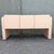 Striking vintage credenza featuring a soft blush pink laminate finish and bold Art Deco Revival styling. The streamlined...