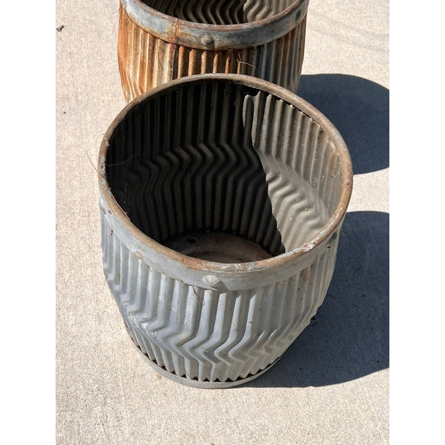 A pair of antique galvanized dolly tub planters with a chevron design from the early 20th century. They are perfect for...