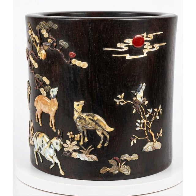 A dark, dense hardwood zitan with raised designs crafted from mother-of-pearl, shell, tinted bone or ivory, and semi-...
