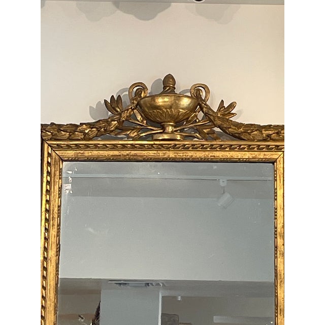 An elegant expression of late 18th century French design, this antique mirror reflects the refined symmetry and restraint...