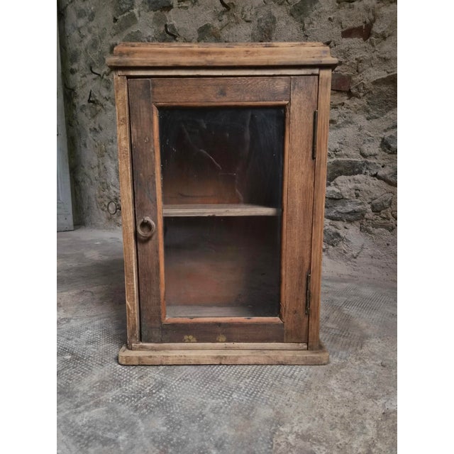 This antique French wall cabinet, dating from circa 1850–1900, is made from solid pine and oak. It features a glazed door...