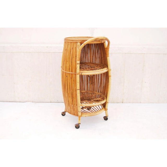 An Italian bar cart in rattan and bamboo from the 1960s, featuring a barrel-shaped design by BONACINA with one curved...