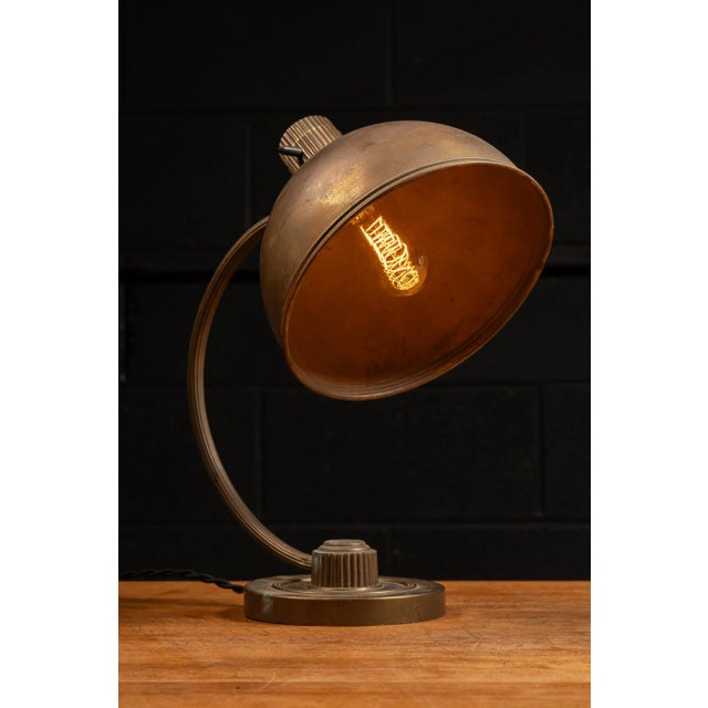 Adjustable brass table lamp with large domed shade. This piece features an all-brass body with adjustable head that...