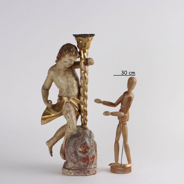 Putto torch holder in carved, lacquered and gilded wood. Restored in lacquering and gilding in the posthumous era. This...