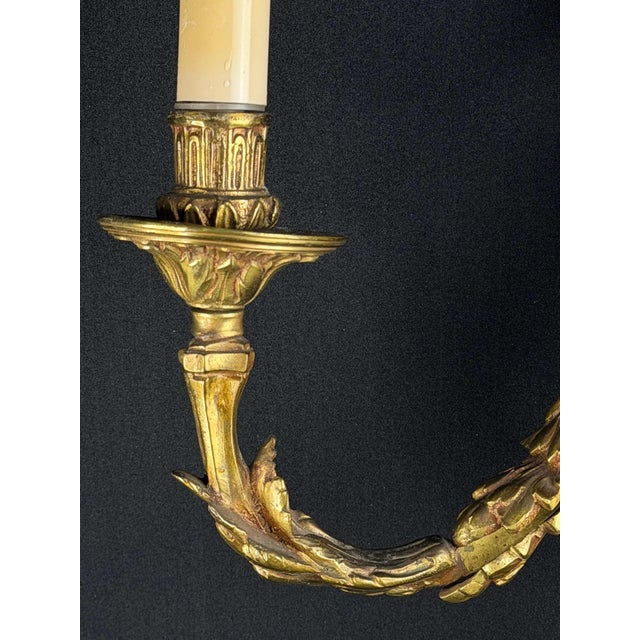 Exceptional late-19th to early-20th-century French Louis XVI gilt bronze wall sconce, featuring a richly cast torch-shaped...