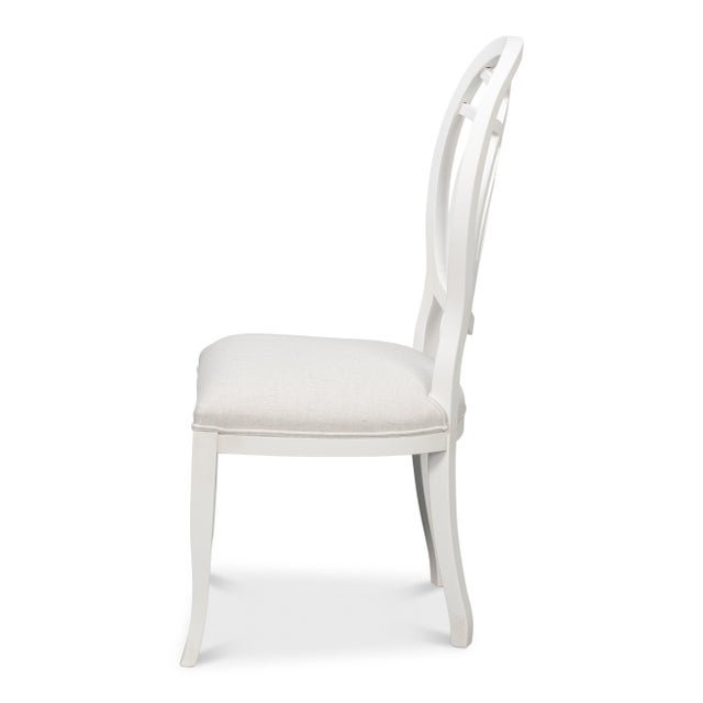 Interlaced loops of carved beechwood form open oval backs that allow a clear view through the ribbon pattern. Painted...