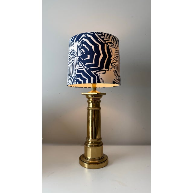 Vintage nautical brass table lamp paired with a navy and white abstract pattern barrel lamp shade.