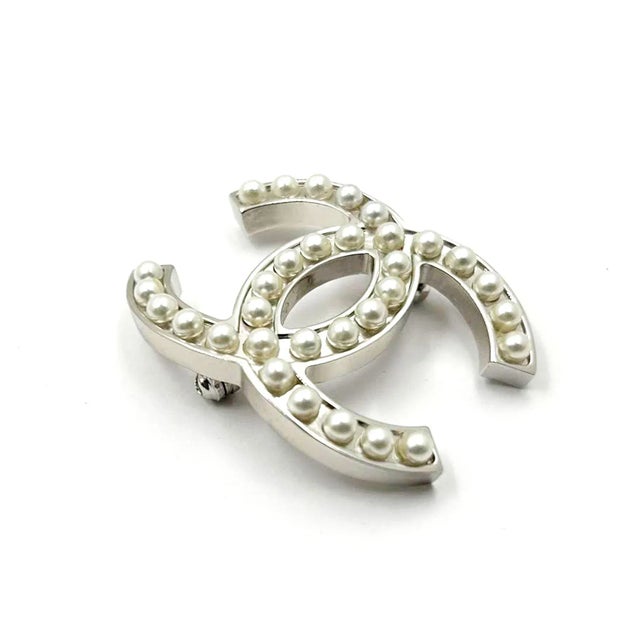 This is part of Chairish’s Costume Jewelry assortment. Chanel Classic Silver CC Pearl Brooch *Marked 05 *Made in France...